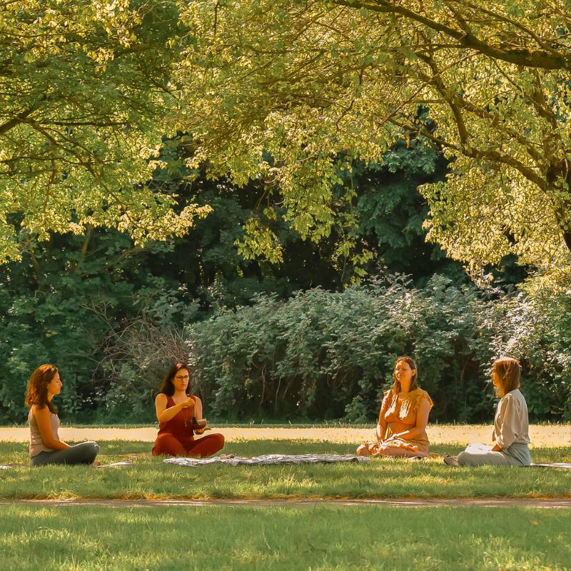 Foto van vier vrouwen zittend in een park voor een vrouwencirkel